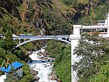 09 Friendship Bridge Between Kodari Nepal And Zhangmu Tibet After Crossing The Friendship Bridge From Kodari After passing through China Customs and Immigration, I walk up the road to our awaiting Landcruiser. I look back to see the thundering Bhote Kosi (�River From Tibet�) flowing under the Friendship Bridge.